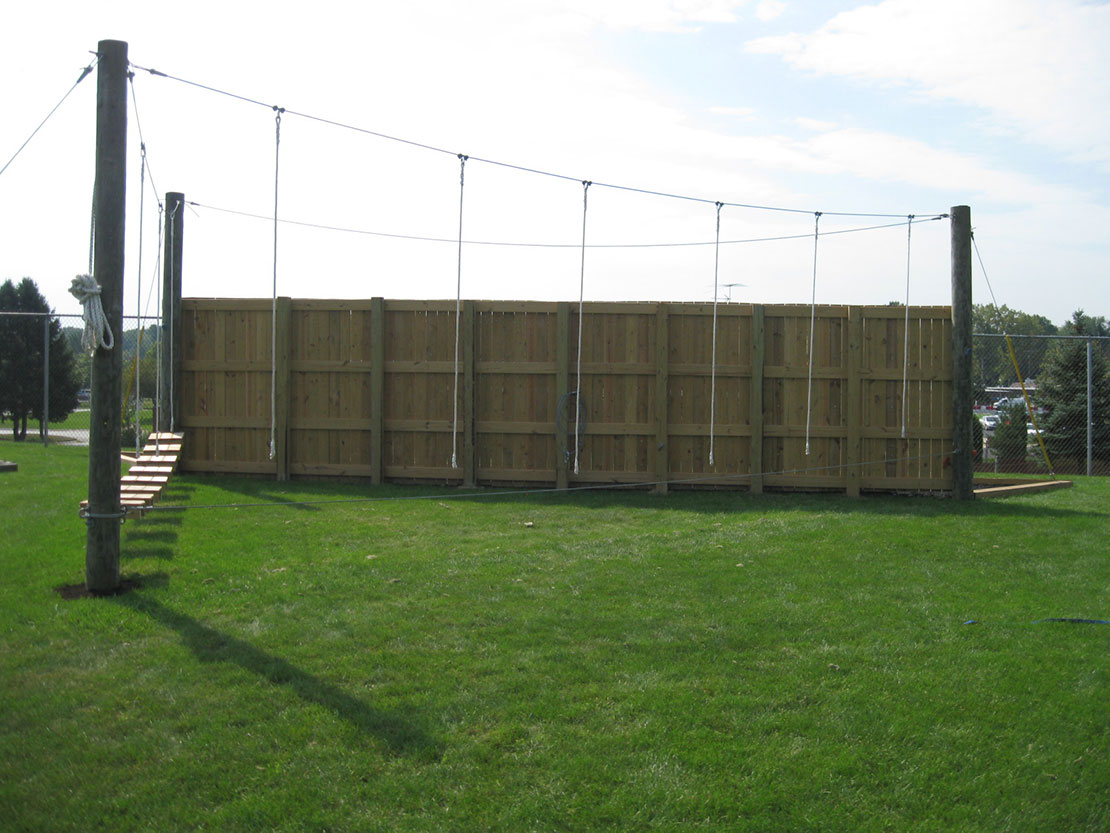 A low ropes course bridge and rope obstacle.