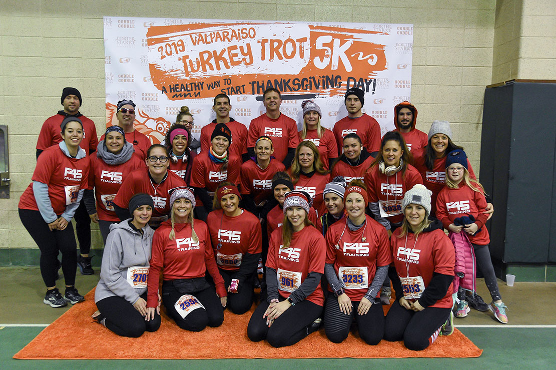 Race participants pose in front of the Valparaiso Turkey Trot banner on Thanksgiving Day.
